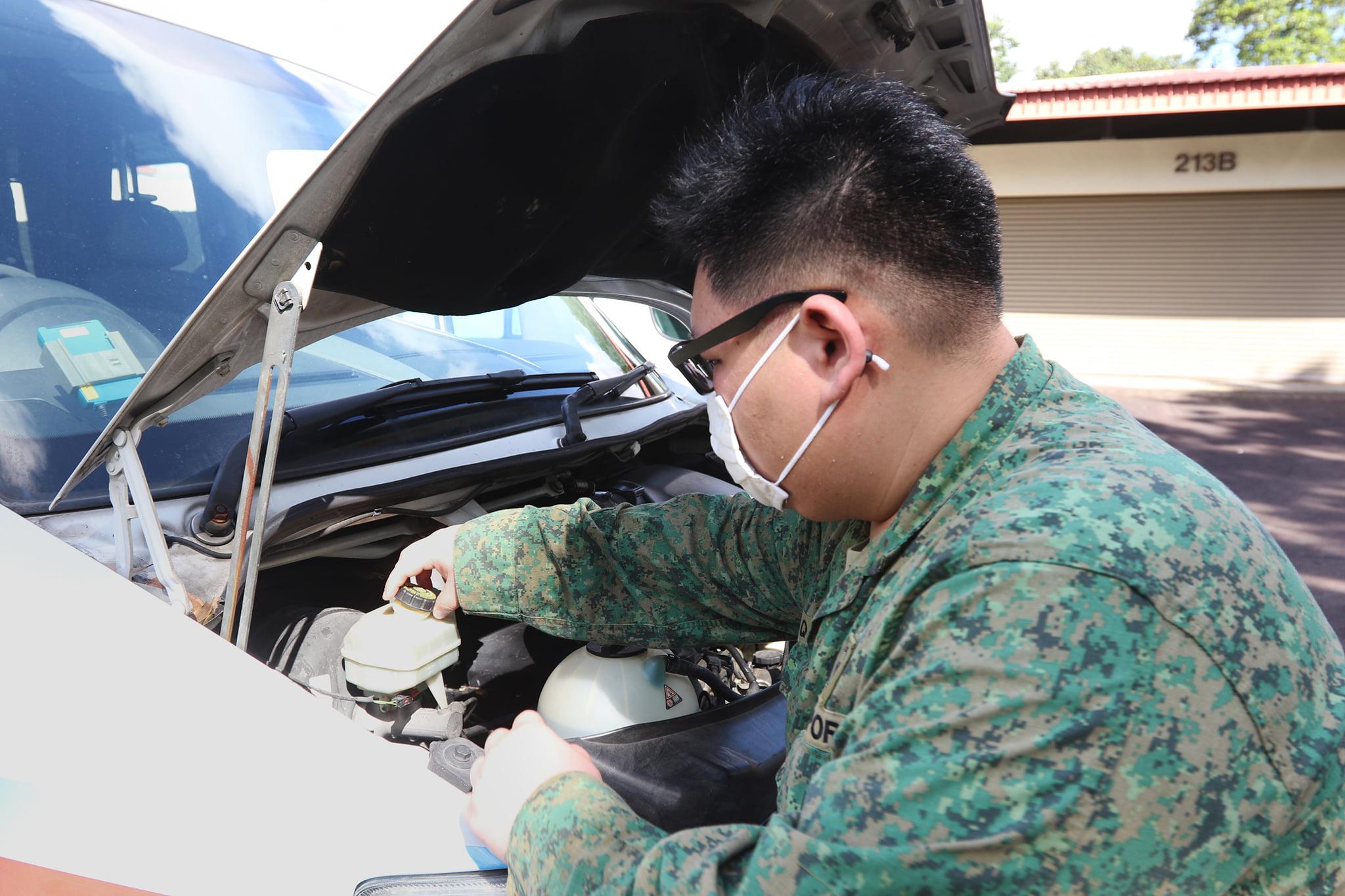 CFC Seah doing checks on the ambulance to ensure that the engine fluid, break fluid, wiper water and power steering were functioning properly.