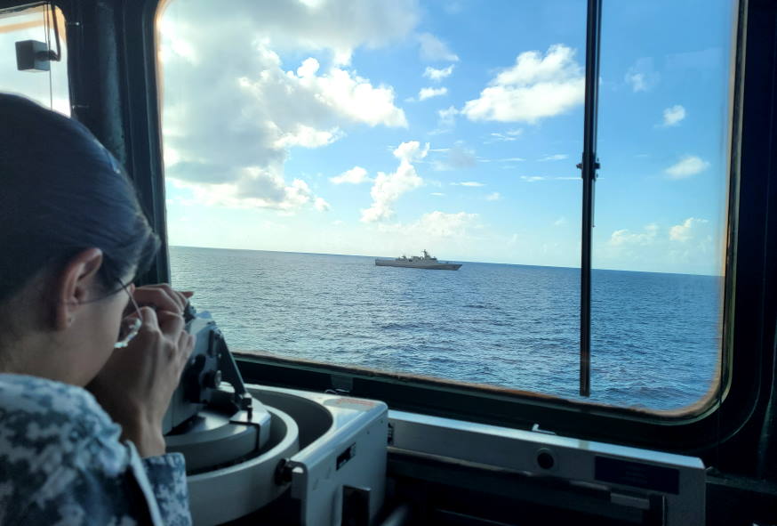 Crew member taking bearing from the KRI Diponegoro as part of the manoeuvring exercise.