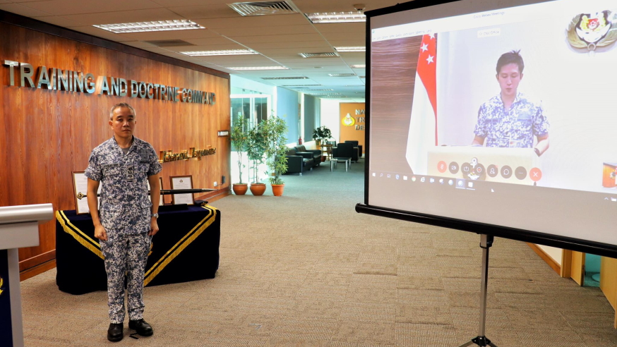 COL Goh standing at attention as Chief of Navy RADM Aaron Beng reads out the Command citation for COL Goh.