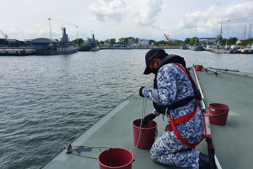 "Special sea duty men and berthing party close up! Ship going alongside berth C1-2, port side to!" A seaman hard at work preparing the heaving lines for coming alongside.