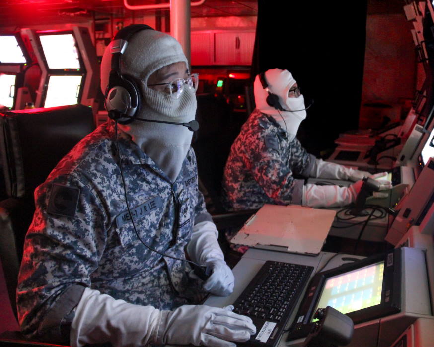 RSS Intrepid's Weapon Control Systems Supervisor ME2 Lee Jun Rong (left) scrutinising the accuracy of each salvo during the live gunnery firing.